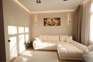 ein Wohnzimmer mit einer weißen Couch und einem Fenster in der Unterkunft Memel Town Apartments in Klaipėda + 29 Fotos