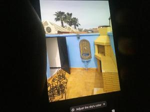 einen TV-Bildschirm mit einem Bild eines Gebäudes in der Unterkunft Marrakech village touristique in Marrakesch