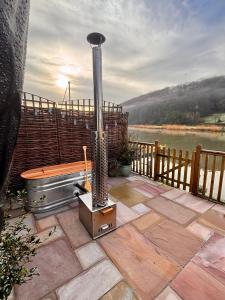a hot tub and a grill on a patio at Viaduct River View & Outdoor Bath - Couples Retreat in Calstock +6 photos