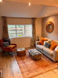 a living room with a couch and a chair at Viaduct River View & Outdoor Bath - Couples Retreat in Calstock