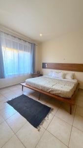 a large bed in a bedroom with a large window at Lush Urbarn Oasis in Kampala