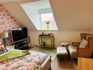 a bedroom with a bed and a tv and a chair at Number 2, Spacious Rooms, Near Ironbridge! in Telford