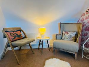 a room with two chairs and a table and a lamp at Number 2, Spacious Rooms, Near Ironbridge! in Telford