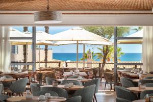 a restaurant with tables and chairs and umbrellas at Grande Real Santa Eulalia Resort & Hotel Spa in Albufeira