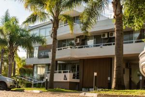 a building with palm trees in front of it at Aguasol Hotel Termal in Termas del Daymán