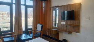 a hotel room with a tv and a bed and a window at zoz Jhelum river in Srinagar