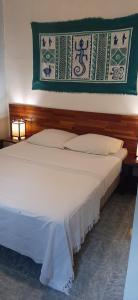 een groot wit bed in een kamer met 2 lampen bij Appartement LONGANIS in Saint-Gilles-les-Bains