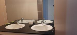 een badkamer met 3 wastafels en een spiegel bij Appartement LONGANIS in Saint-Gilles-les-Bains