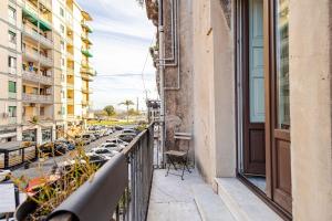 a balcony of a building with cars parked on the street at Elephant's Smile B&B in Catania