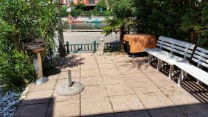 eine Parkbank neben einem Brunnen und einem Vogelfutterhaus in der Unterkunft Casa 712 in Caleri