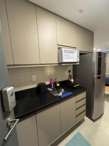 a kitchen with a sink and a refrigerator at Flat a poucos metros do mar in Cabedelo