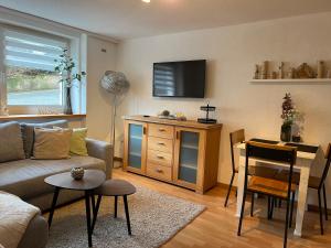 ein Wohnzimmer mit Sofa und Fernseher in der Unterkunft Ferienwohnung Rösler in Niederfüllbach + 6 Fotos