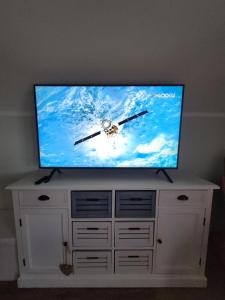 a flat screen tv sitting on top of a white cabinet at Ferienwohnung Macht in Furth im Wald
