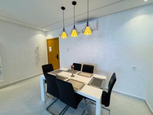 een eetkamer met een witte tafel en zwarte stoelen bij Modern Apartment in the heart of Tangier in Tanger +37 foto's