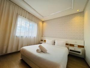 een slaapkamer met een groot wit bed en een raam bij Modern Apartment in the heart of Tangier in Tanger