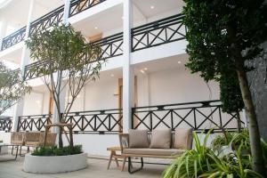a lobby with a couch and chairs and trees at Ruby Hotel in Vientiane