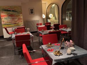 a dining room with tables and red chairs at Apart Hotel Fulda in Fulda