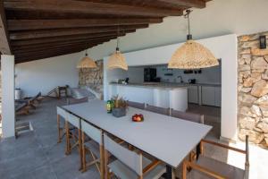 una cucina e una sala da pranzo con tavolo e sedie bianchi di Mediterranean Villa next to Sea a Klek
