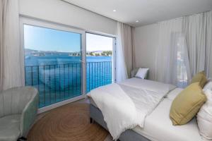 una camera da letto con un letto e una grande finestra di Mediterranean Villa next to Sea a Klek