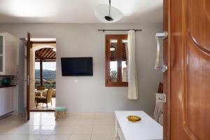 ein Wohnzimmer mit einem Tisch und einem Fernseher an der Wand in der Unterkunft Bezari pool villa in Metochia Fratzeskiana