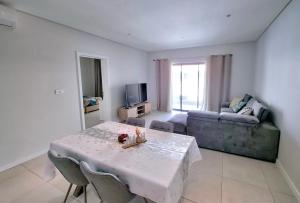 Soleia 2 - Pereybere - Appartement Cozy avec piscine proche plage في غراند بايَ: غرفة معيشة بها طاولة وأريكة +20 صورة