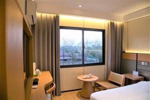 a hotel room with a bed and a table and a window at Ruby Hotel in Vientiane +37 photos
