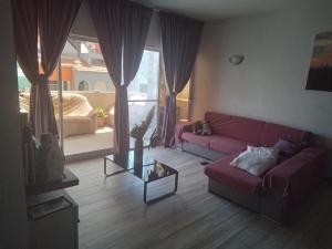 Una sala de estar con un sofá rojo y una mesa. en Relache House Praia, en Praia