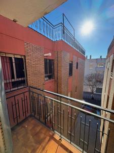 einen Balkon eines Gebäudes mit Geländer und Gebäude in der Unterkunft Apartamento espacioso El Olivo in Córdoba