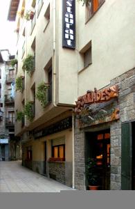 a building with a sign on the side of it at Hostal Les Collades in Sort