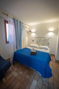 una camera da letto con un letto blu e una finestra di Lighthouse Taranto a Taranto
