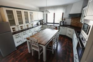 a kitchen with a wooden table and white cabinets at Das Hexenlandhaus Tom, Oberharz, mit Sauna in Braunlage