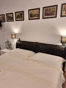 two beds in a bedroom with a leather headboard at Appartamento Merano nel cuore in Merano +23 photos