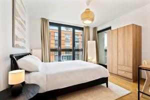 阿尔泽特河畔埃施A Stylish Retreat in Esch Urban Landscape的卧室里有一张白色的床和一扇大窗户