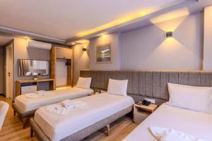 a hotel room with two beds with white sheets at EViM HOTEL ÇORLU in Çorlu