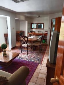 a living room with a table and chairs at Comodo Hostal para personas de trabajo in Linares