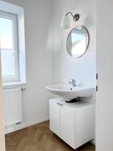 a white bathroom with a sink and a mirror at Apartment auf Zeit - Die Sitzenberger Bettenburg in Reidling