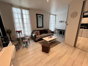 a living room with a couch and a table at Appartement cosy in Trouville-sur-Mer