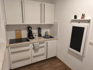 a small kitchen with white cabinets and a sink at Ferienwohnung Aggelina in Bad Neuenahr-Ahrweiler