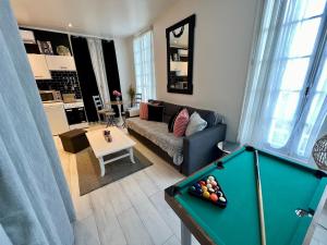 a living room with a pool table in a living room at Appartement cosy in Trouville-sur-Mer