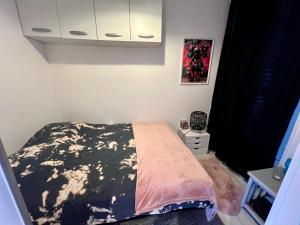 a bedroom with a bed with a black and white comforter at Appartement cosy in Trouville-sur-Mer