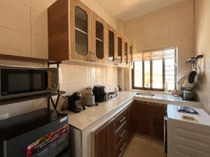 una cucina con forno a microonde e frigorifero di Résidence Atlantis F2 avec balcon vue sur mer a Dakar