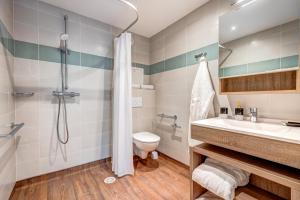 un bagno con doccia, WC e lavandino di Zenao Appart'hôtels Le Raincy Thiers a Le Raincy