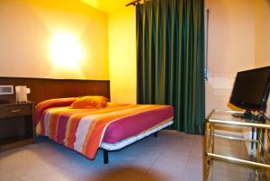 1 dormitorio con 1 cama y TV en Hostal Les Collades, en Sort