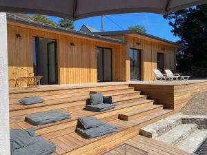 ein Gebäude mit einer Terrasse mit Kissen darauf in der Unterkunft Villa La Foliotte in Saint-Pair-sur-Mer