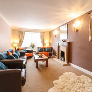 a living room with couches and a fireplace at Brandeston Close in Great Waldingfield