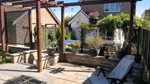 a patio with a pergola and potted plants at Brandeston Close in Waldingfield