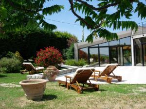 a group of chairs sitting in the grass in front of a house at B&B La Torretta in Tavullia