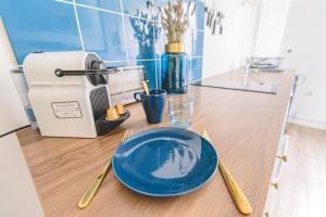 a blue plate sitting on a counter next to a toaster at Azul Cosy charmant proche centre in Reims +5 photos