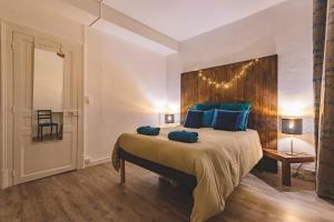 a bedroom with a large bed with blue pillows at Azul Cosy charmant proche centre in Reims