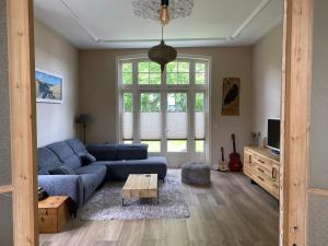 アッカースロートにあるVilla free standing 25 min Amsterdam 10 min beachの青いソファとテーブルのあるリビングルーム